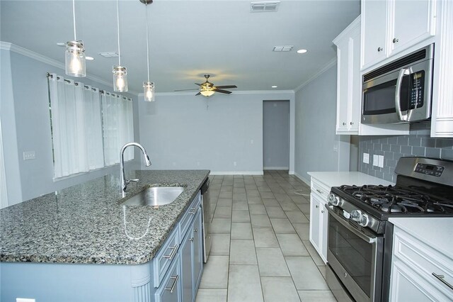 15414 Dyna St, Corpus Christi, TX 78418 - kitchen featuring appliances with stainless steel finishes, ornamental molding, white cabinetry, an island with sink, and backsplash