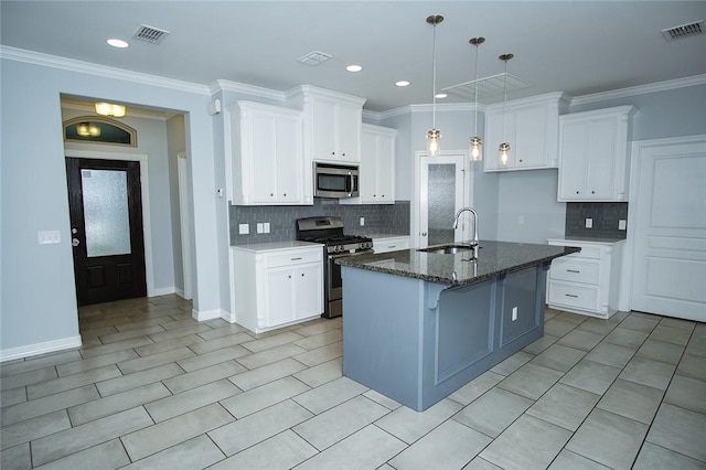 15414 Dyna St, Corpus Christi, TX 78418 - kitchen featuring stainless steel appliances, decorative backsplash, white cabinets, a kitchen island with sink, and dark stone countertops