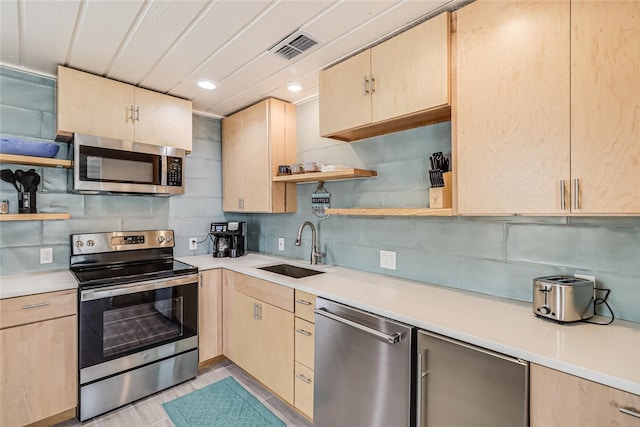 kitchen featuring light brown cabinetry, sink, backsplash, and appliances with stainless steel finishes