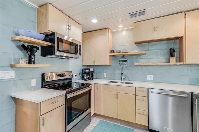 kitchen with appliances with stainless steel finishes, sink, decorative backsplash, and light brown cabinets