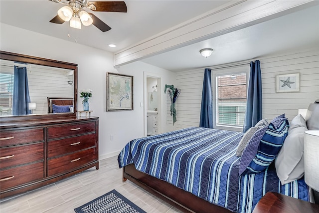 bedroom with ensuite bathroom, light wood-type flooring, ceiling fan, and beam ceiling