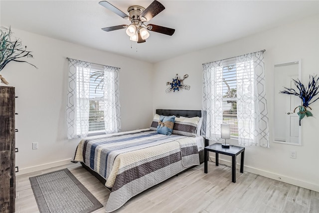 bedroom with multiple windows, ceiling fan, and light wood-type flooring