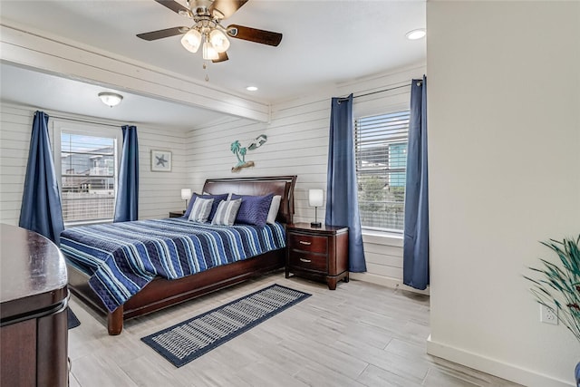 bedroom featuring beam ceiling, ceiling fan, and light wood-type flooring