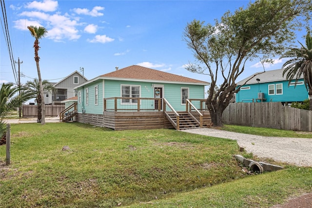 view of front facade with a wooden deck and a front yard