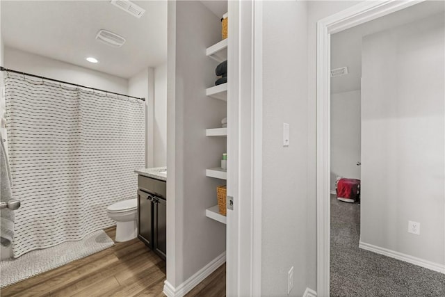 bathroom with vanity, wood-type flooring, curtained shower, and toilet