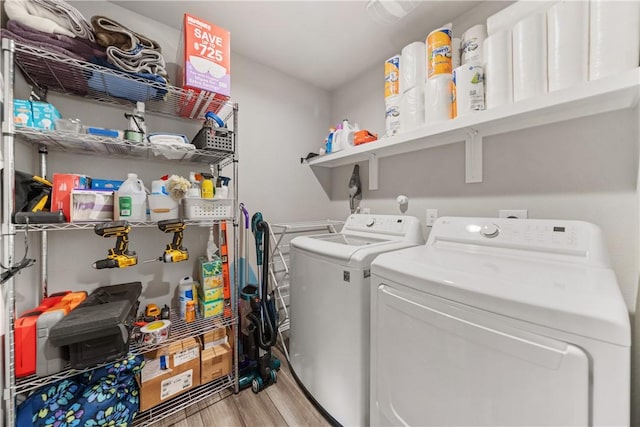 laundry room featuring washer and dryer and light wood-type flooring