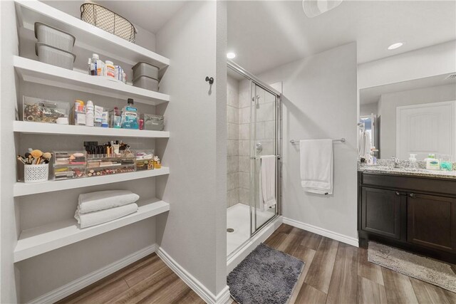 bathroom with vanity, a shower with door, and hardwood / wood-style floors