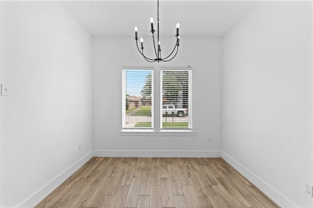4209 Walnut Hills Dr, Corpus Christi, TX 78413 - spare room featuring a chandelier, light wood-style flooring, and baseboards