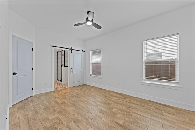 4209 Walnut Hills Dr, Corpus Christi, TX 78413 - unfurnished bedroom with a barn door, light wood-type flooring, baseboards, and ceiling fan