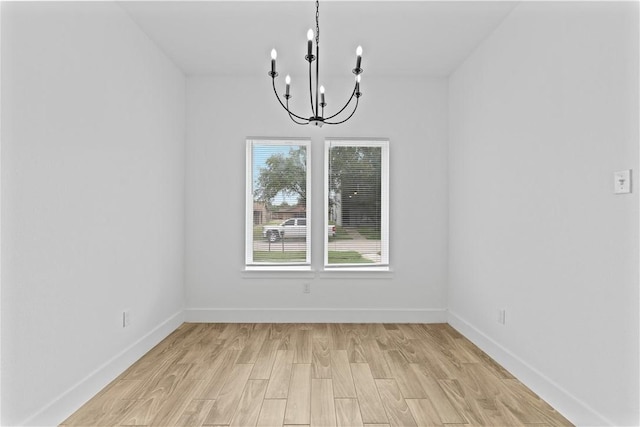 4209 Walnut Hills Dr, Corpus Christi, TX 78413 - spare room with a chandelier, light wood-type flooring, and baseboards