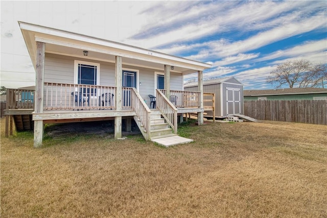 back of property featuring a yard, covered porch, and a storage unit