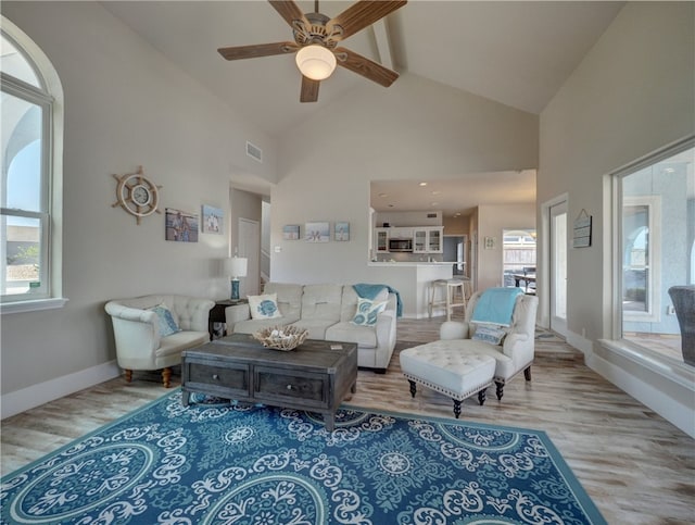 living room with ceiling fan, high vaulted ceiling, and hardwood / wood-style floors