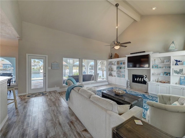 living room featuring ceiling fan, high vaulted ceiling, and beamed ceiling