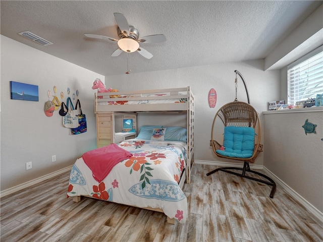 bedroom featuring a textured ceiling, ceiling fan, and light hardwood / wood-style floors