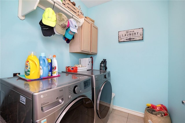 laundry area with baseboards, cabinet space, washing machine and clothes dryer, and light tile patterned flooring