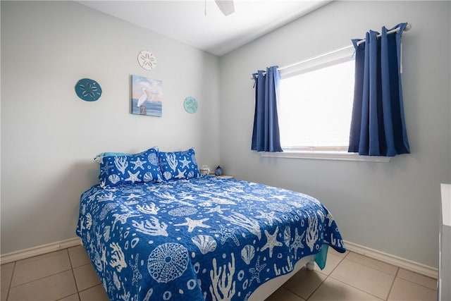 bedroom with a ceiling fan, tile patterned flooring, and baseboards