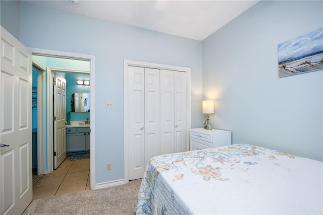 bedroom with light carpet, light tile patterned floors, a closet, and a sink