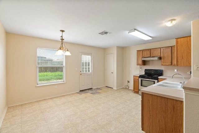 1606 W Nelson Ave, Aransas Pass, TX 78336 - kitchen featuring stainless steel range with electric stovetop, under cabinet range hood, light countertops, brown cabinets, and hanging light fixtures