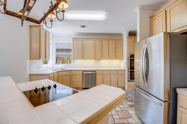 6302 Grandvilliers Dr, Corpus Christi, TX 78414 - kitchen with stainless steel appliances, light brown cabinetry, tile counters, crown molding, and light stone finish flooring