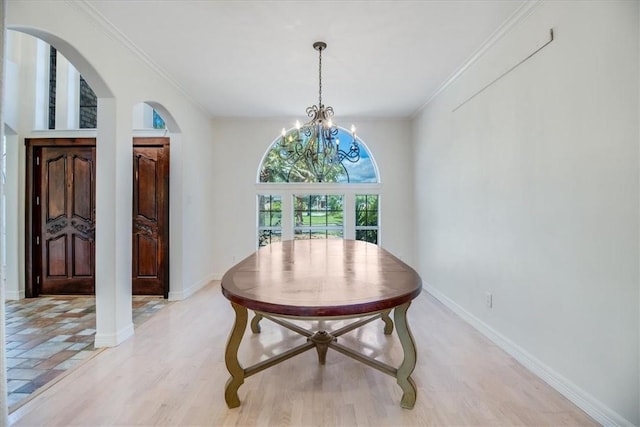 6302 Grandvilliers Dr, Corpus Christi, TX 78414 - dining area featuring a chandelier, arched walkways, light wood finished floors, and crown molding