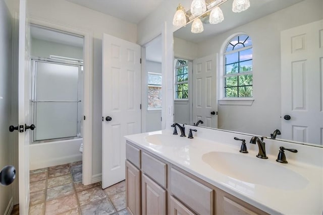 6302 Grandvilliers Dr, Corpus Christi, TX 78414 - full bath with double vanity, bath / shower combo with glass door, and stone finish flooring