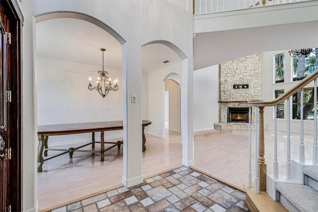 6302 Grandvilliers Dr, Corpus Christi, TX 78414 - entrance foyer with a chandelier, a stone fireplace, a towering ceiling, arched walkways, and stairway