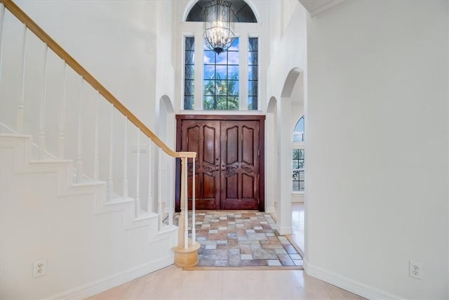 6302 Grandvilliers Dr, Corpus Christi, TX 78414 - entrance foyer featuring a high ceiling, a chandelier, arched walkways, stairway, and stone finish flooring