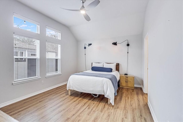 bedroom featuring lofted ceiling, light wood-style floors, ceiling fan, and baseboards