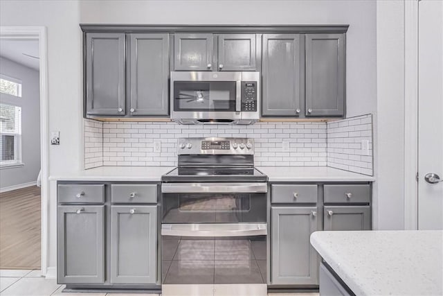 kitchen featuring tasteful backsplash, gray cabinets, and stainless steel appliances