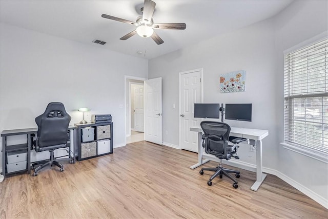 home office featuring visible vents, ceiling fan, baseboards, and wood finished floors