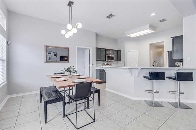 dining room featuring a chandelier, visible vents, baseboards, and light tile patterned floors