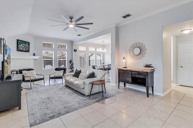 living area featuring light tile patterned floors, baseboards, visible vents, a ceiling fan, and ornamental molding