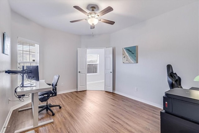 office featuring wood finished floors, a ceiling fan, and baseboards