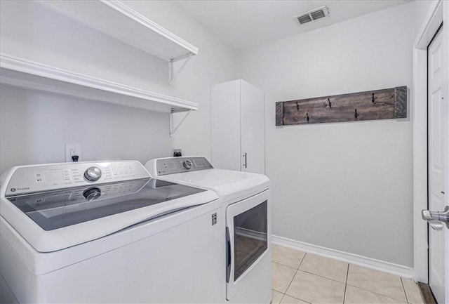 laundry area featuring laundry area, light tile patterned floors, baseboards, visible vents, and independent washer and dryer