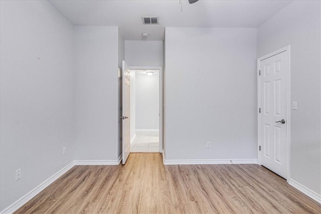 unfurnished bedroom featuring light wood-type flooring, baseboards, and visible vents