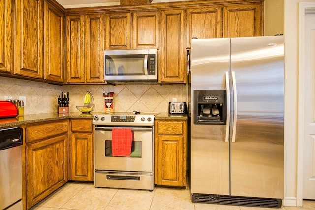 324 Nicklaus Dr, Portland, TX 78374 - kitchen featuring light tile patterned flooring, appliances with stainless steel finishes, backsplash, and dark stone counters