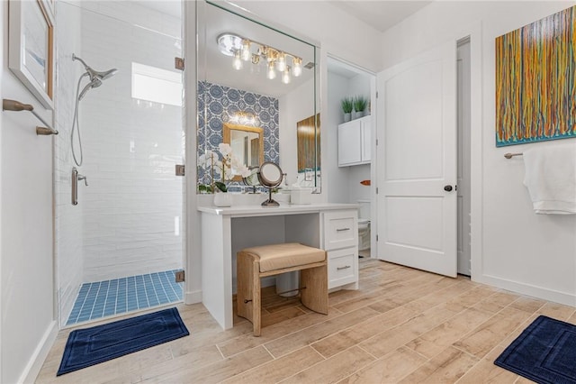 bathroom with toilet, vanity, a shower with shower door, and hardwood / wood-style flooring