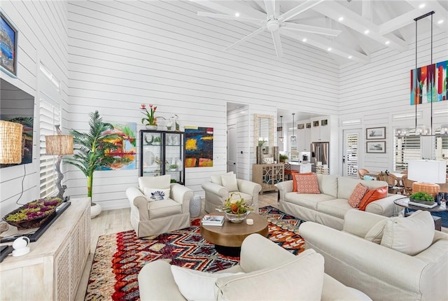 living room featuring ceiling fan, beamed ceiling, high vaulted ceiling, and hardwood / wood-style flooring