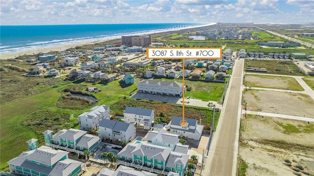 bird's eye view with a water view and a beach view