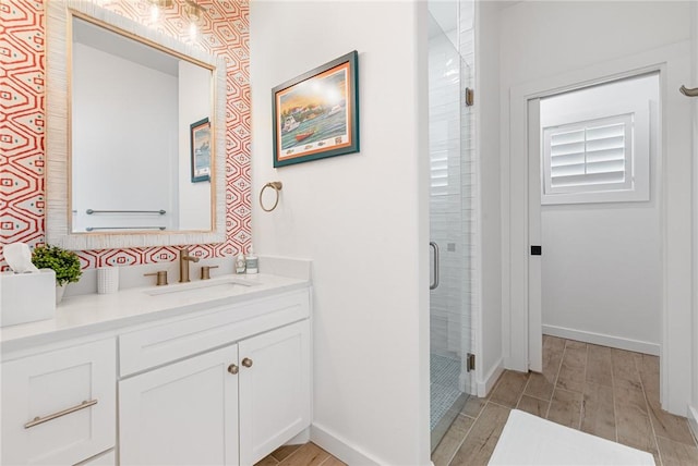 bathroom with hardwood / wood-style floors, vanity, and walk in shower