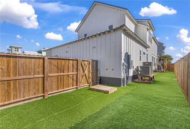 exterior space featuring central air condition unit and a lawn