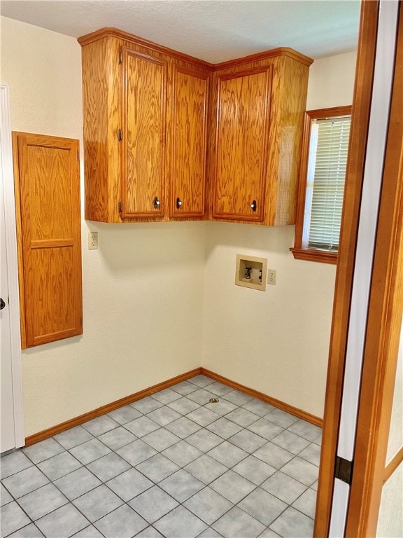 laundry area featuring hookup for a washing machine, cabinets, and light tile patterned floors