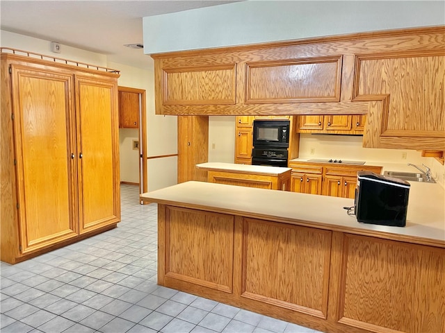 kitchen featuring kitchen peninsula, black appliances, sink, and light tile patterned flooring