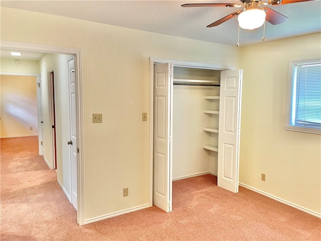 unfurnished bedroom featuring a closet, light carpet, and ceiling fan