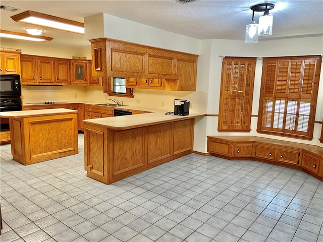 kitchen featuring light tile patterned flooring, black appliances, kitchen peninsula, a textured ceiling, and hanging light fixtures