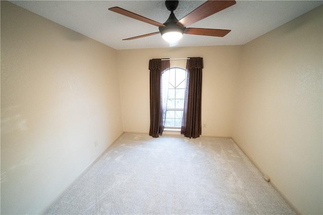 carpeted spare room featuring ceiling fan