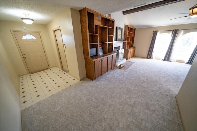 living room with light carpet, a textured ceiling, ceiling fan, and beamed ceiling