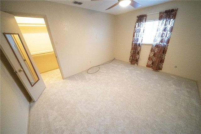 spare room featuring light colored carpet and ceiling fan