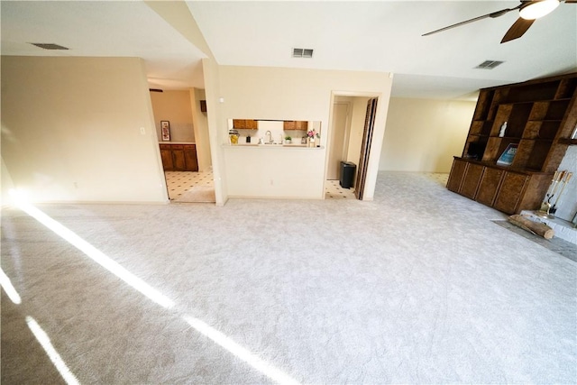 unfurnished living room featuring ceiling fan and sink