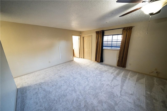 carpeted empty room with a textured ceiling and ceiling fan